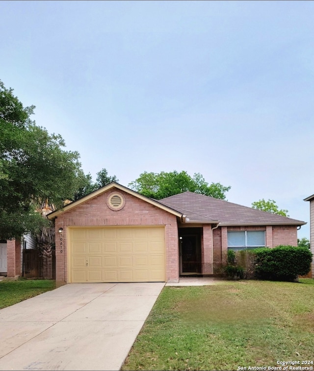 ranch-style house featuring a front yard and a garage