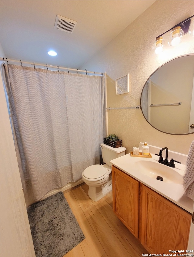 bathroom featuring vanity, toilet, and hardwood / wood-style flooring