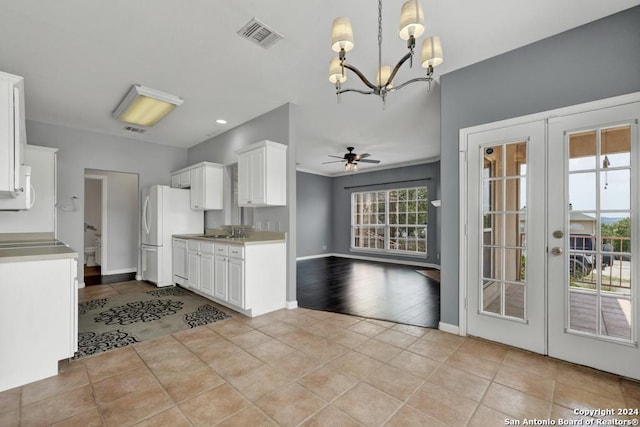 kitchen with french doors, pendant lighting, light tile floors, and white cabinetry