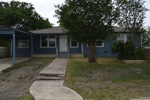 view of front of house with a carport and a front lawn