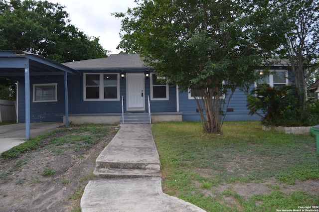 bungalow-style house featuring a front yard and a carport