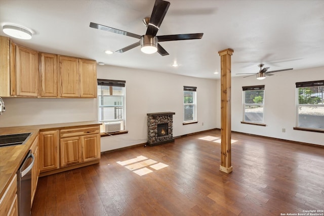 kitchen featuring a stone fireplace, ceiling fan, dark hardwood / wood-style floors, and stainless steel dishwasher