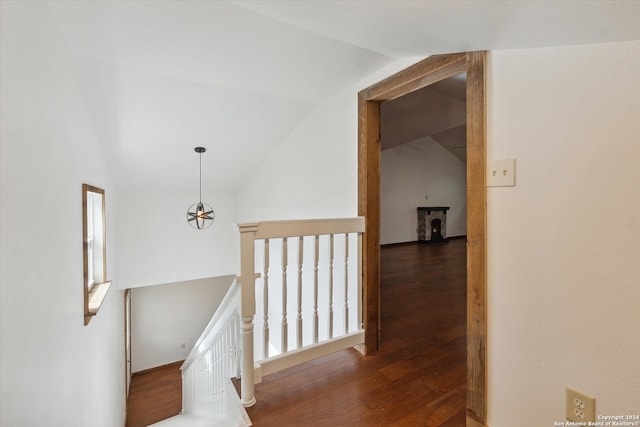 corridor with lofted ceiling and dark hardwood / wood-style floors