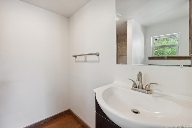 bathroom featuring vanity with extensive cabinet space and hardwood / wood-style floors