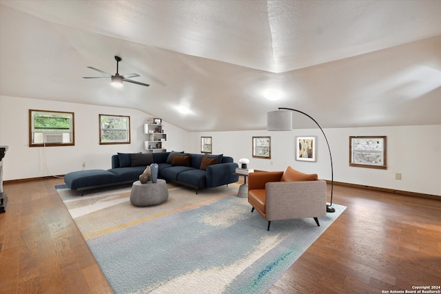 living room featuring ceiling fan, hardwood / wood-style floors, and vaulted ceiling