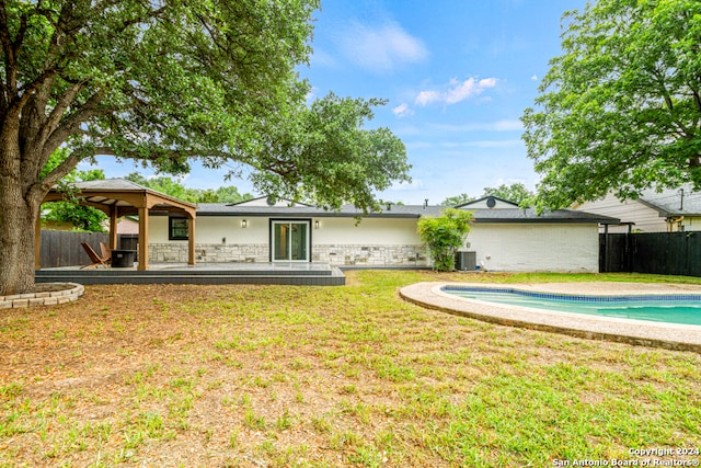 back of house featuring central AC, a patio, a yard, and a fenced in pool