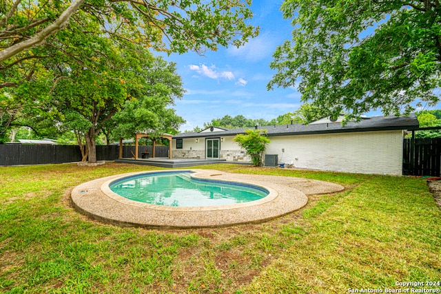 view of swimming pool featuring a yard, central air condition unit, and a patio