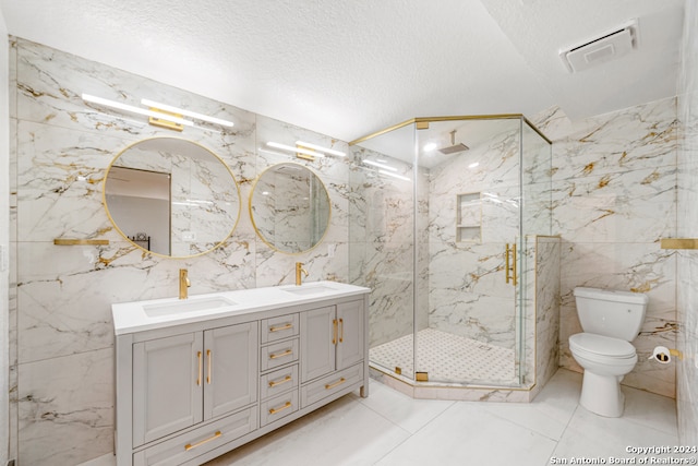 bathroom featuring tile walls, tile flooring, a shower with shower door, and double sink vanity