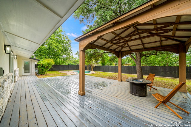 wooden deck featuring a fire pit and a gazebo