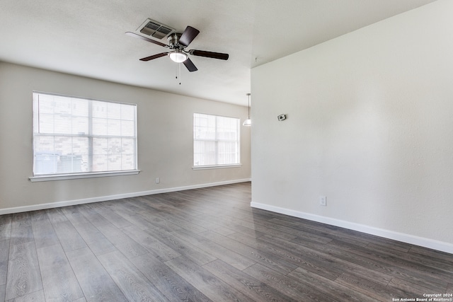 empty room with ceiling fan and dark hardwood / wood-style flooring