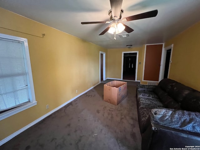 unfurnished living room featuring dark colored carpet and ceiling fan