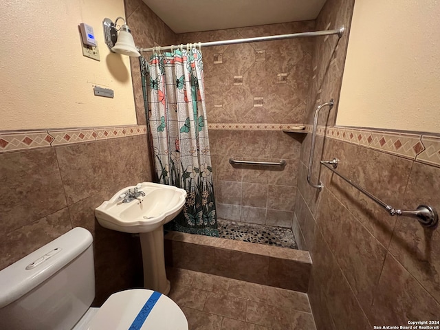 bathroom with curtained shower, toilet, and tile walls