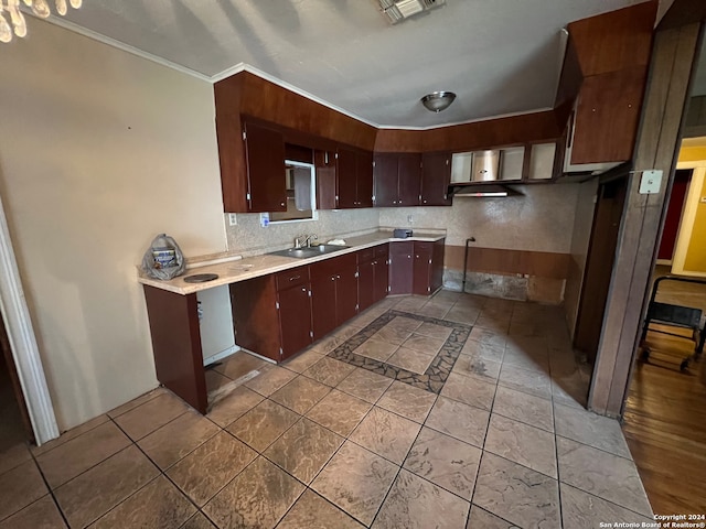 kitchen with ornamental molding, tile flooring, dark brown cabinetry, and sink