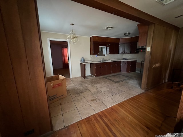 kitchen featuring sink, an inviting chandelier, light tile floors, and decorative light fixtures