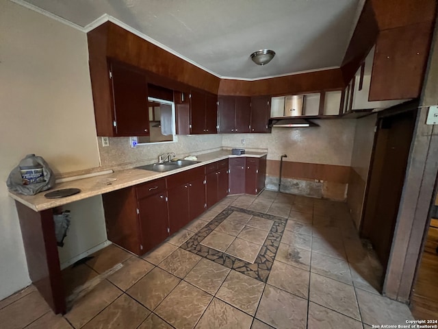 kitchen with dark brown cabinets, crown molding, light tile flooring, tasteful backsplash, and sink