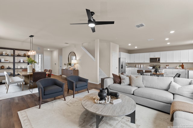 living room with light hardwood / wood-style flooring and ceiling fan