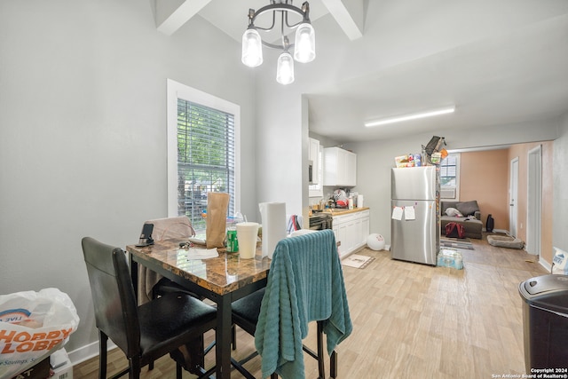 dining space with light hardwood / wood-style flooring and a chandelier