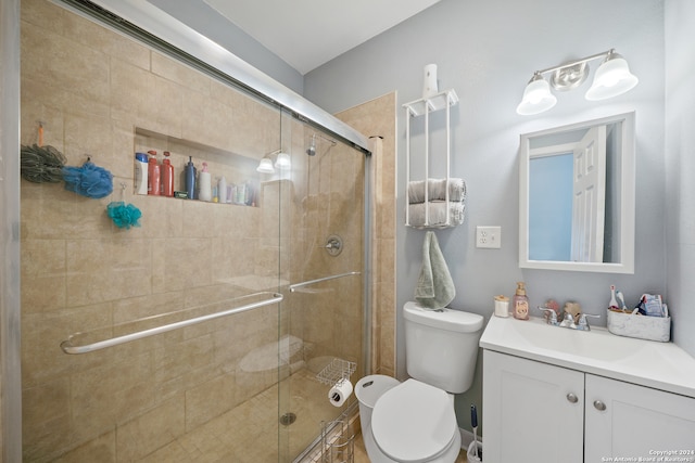 bathroom with a shower with shower door, toilet, and vanity