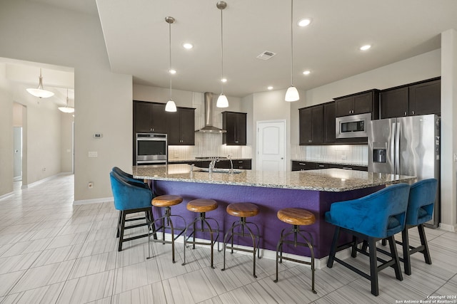 kitchen with backsplash, a large island, wall chimney exhaust hood, and stainless steel appliances