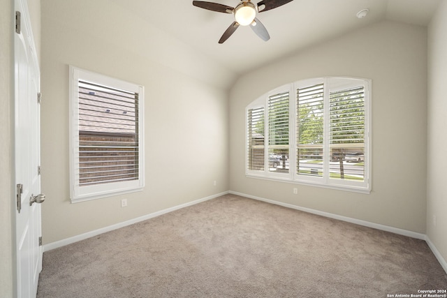 carpeted spare room with ceiling fan and vaulted ceiling