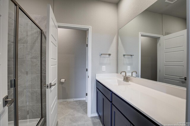 bathroom with vanity, a shower with shower door, and tile patterned flooring