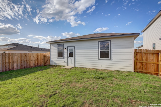 rear view of property featuring a lawn