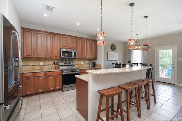 kitchen with backsplash, stainless steel appliances, light tile floors, and hanging light fixtures