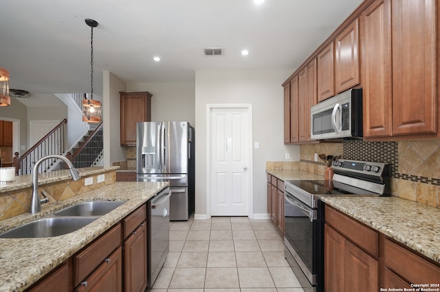 kitchen with pendant lighting, backsplash, appliances with stainless steel finishes, light tile floors, and sink