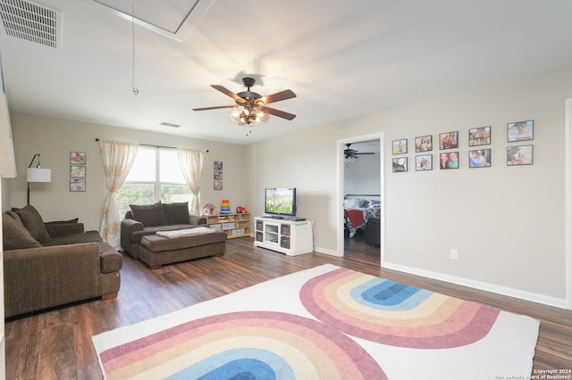 living room featuring ceiling fan and dark hardwood / wood-style floors