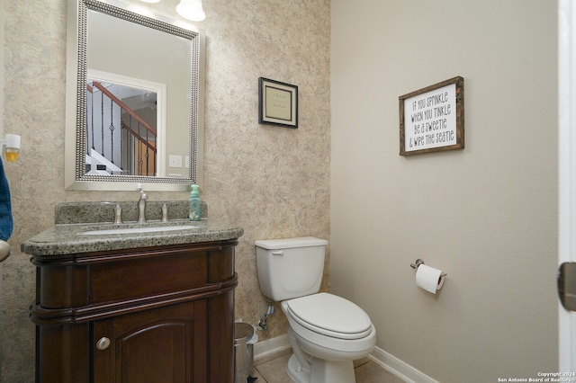 bathroom with toilet, tile flooring, and vanity