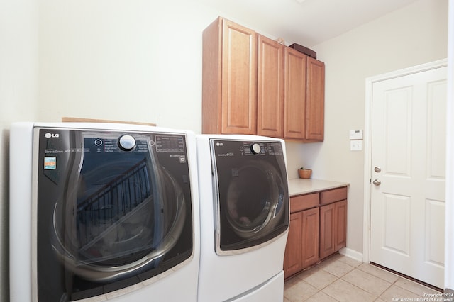 laundry area featuring independent washer and dryer, cabinets, and light tile floors