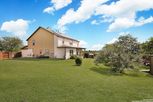 rear view of property featuring a lawn