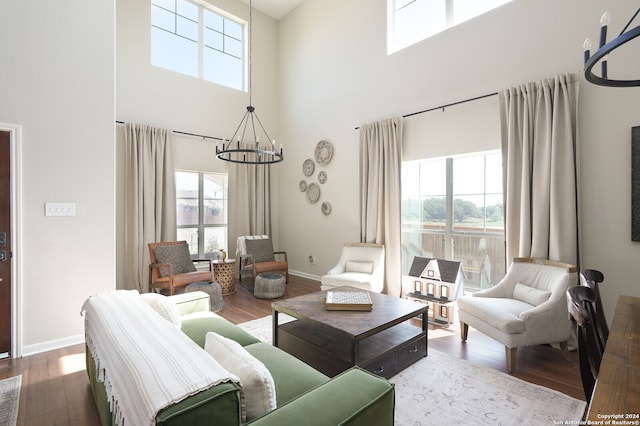 living room with plenty of natural light, hardwood / wood-style flooring, and an inviting chandelier