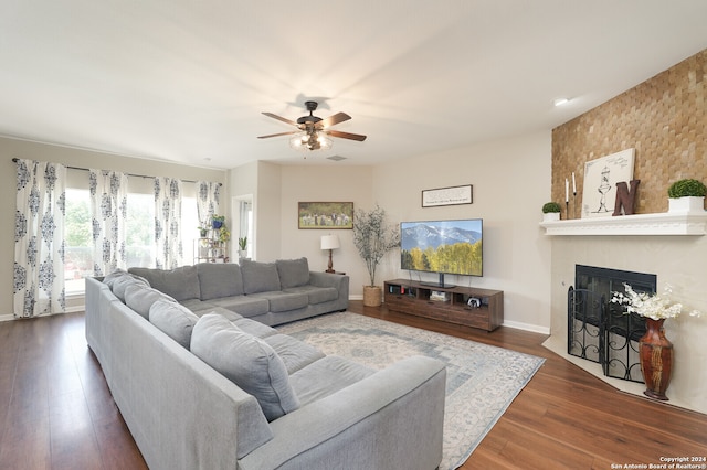 living room featuring dark wood-type flooring and ceiling fan