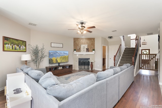 living room featuring dark hardwood / wood-style flooring, ceiling fan, and a fireplace