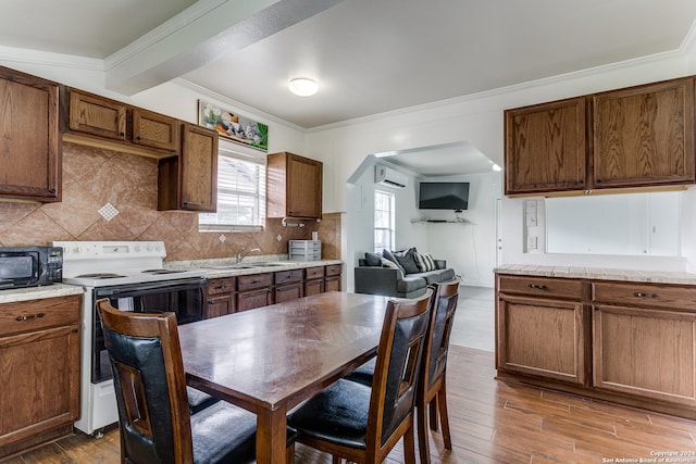 kitchen featuring backsplash, white electric range oven, an AC wall unit, crown molding, and hardwood / wood-style flooring