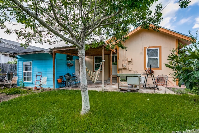 back of property featuring a patio area and a yard