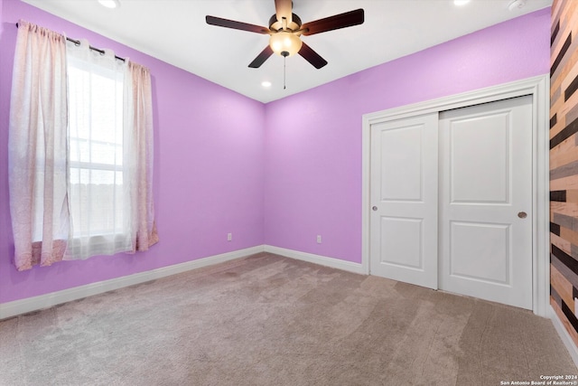 unfurnished bedroom with a closet, ceiling fan, and carpet floors