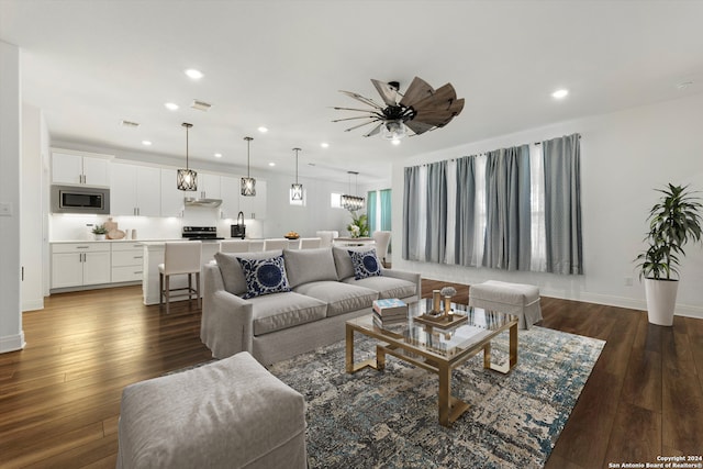 living room with dark wood-type flooring and ceiling fan