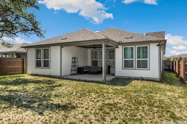 rear view of property with an outdoor living space, ceiling fan, a patio area, and a lawn