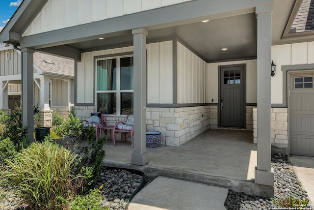 doorway to property with a garage and covered porch