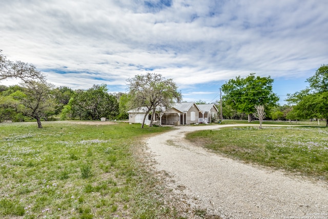 view of front of home featuring gravel driveway and a front lawn