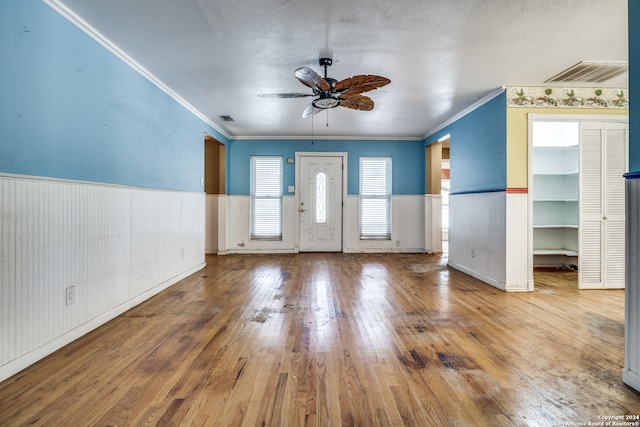 entrance foyer featuring a textured ceiling, hardwood / wood-style floors, ceiling fan, and crown molding