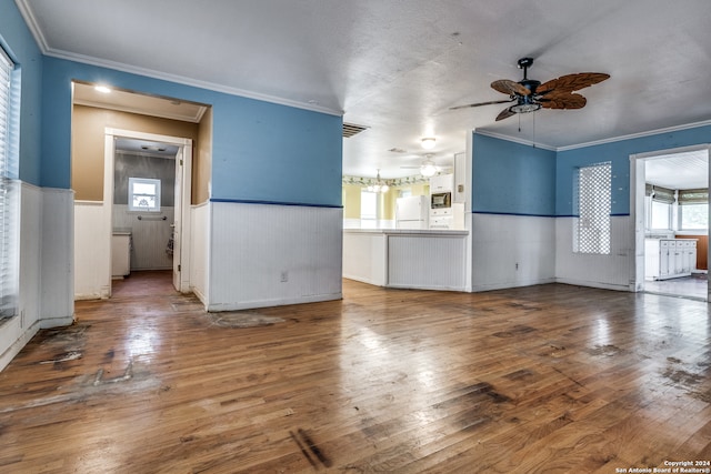 unfurnished living room featuring ceiling fan, hardwood / wood-style flooring, and ornamental molding