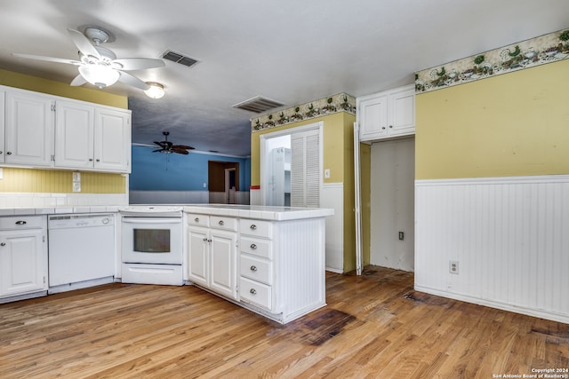 kitchen with kitchen peninsula, light hardwood / wood-style flooring, white appliances, ceiling fan, and white cabinets