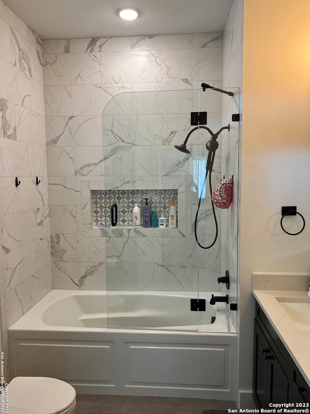 full bathroom featuring toilet, bath / shower combo with glass door, and vanity