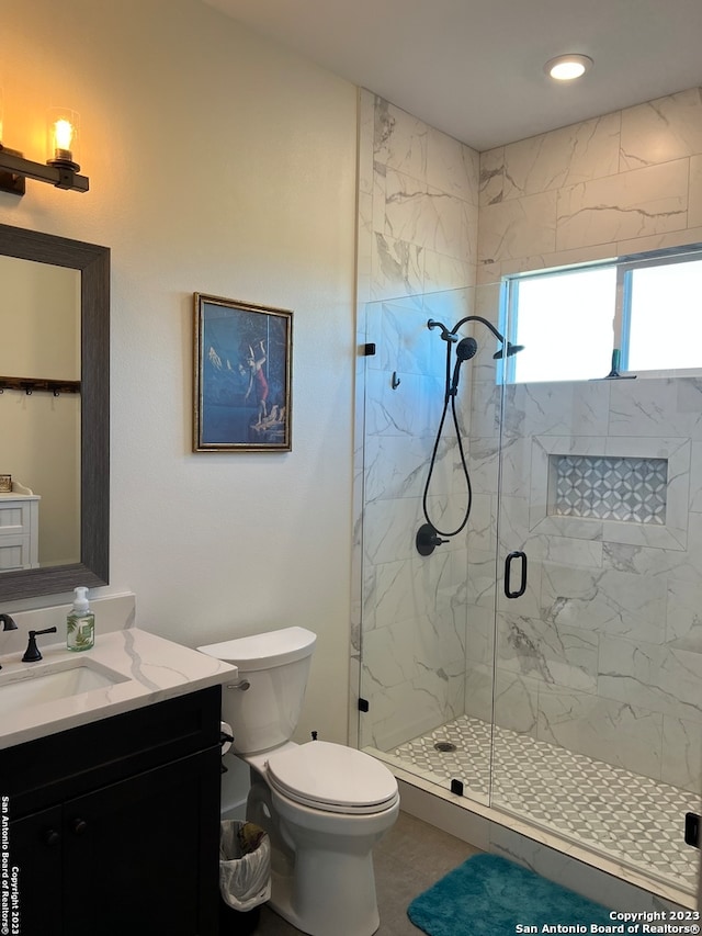 bathroom with an enclosed shower, vanity, and toilet