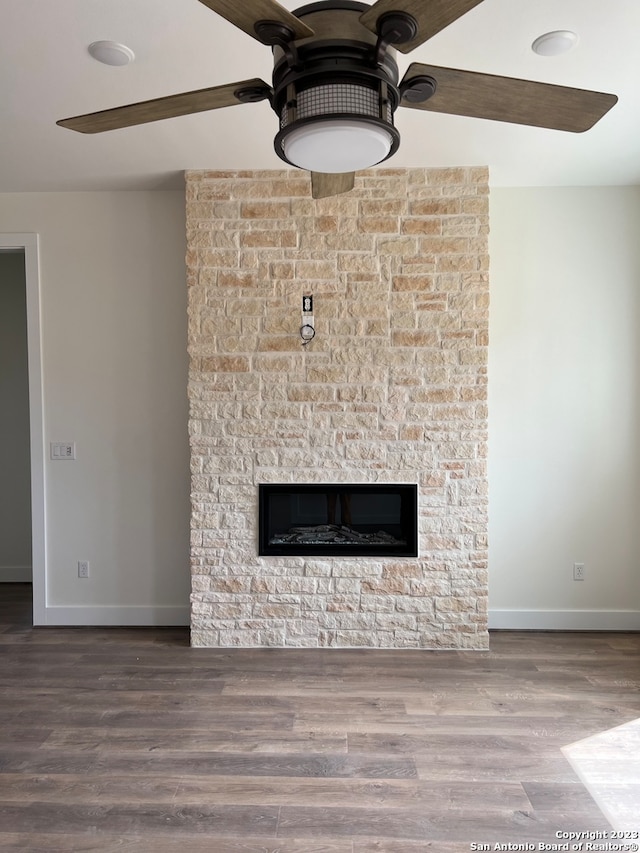 interior details with wood-type flooring, a fireplace, and ceiling fan