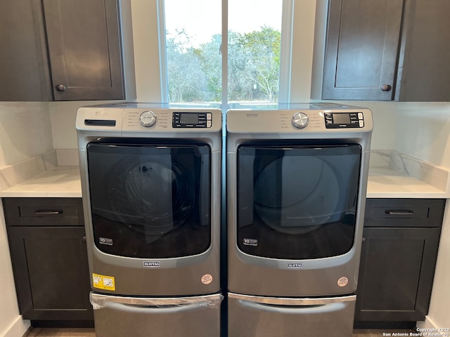 laundry area featuring independent washer and dryer and cabinets