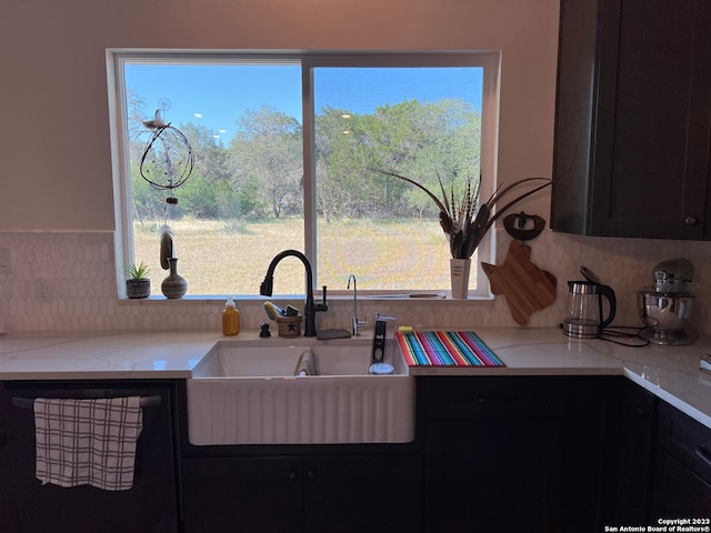 kitchen with dishwasher, sink, and light stone counters